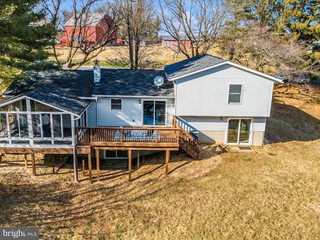 back of property with a yard, a deck, and a sunroom