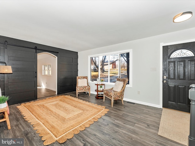 entryway with dark hardwood / wood-style flooring and a barn door