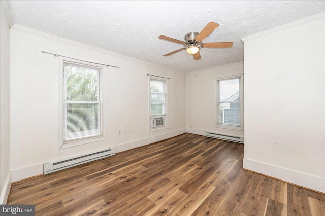 empty room with wood finished floors, a baseboard heating unit, crown molding, and plenty of natural light