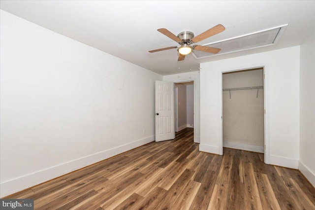 unfurnished bedroom with attic access, a closet, wood finished floors, and baseboards