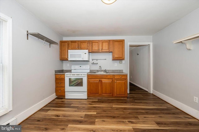 kitchen featuring white appliances, brown cabinets, a sink, baseboards, and dark wood-type flooring