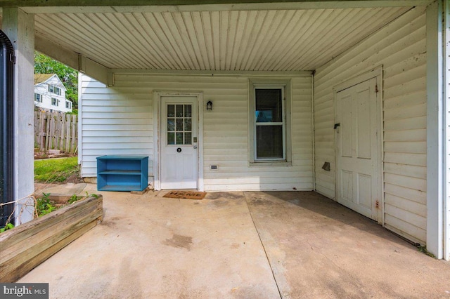 view of exterior entry with a patio area