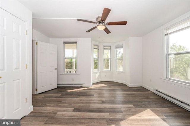 unfurnished room featuring a baseboard heating unit and plenty of natural light