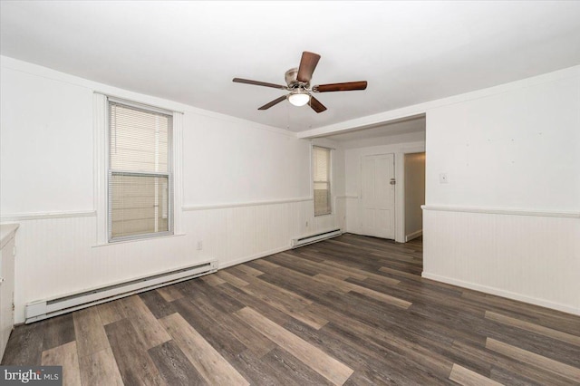 empty room with a baseboard heating unit, a ceiling fan, and wood finished floors