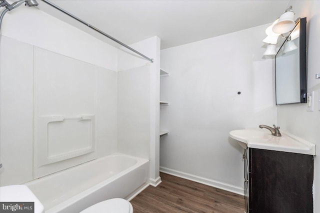bathroom featuring vanity, toilet, baseboards, wood finished floors, and  shower combination