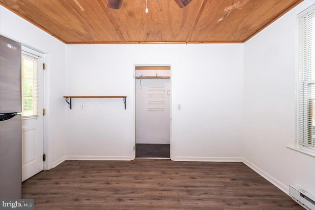 empty room with wood finished floors, wood ceiling, baseboard heating, baseboards, and a ceiling fan