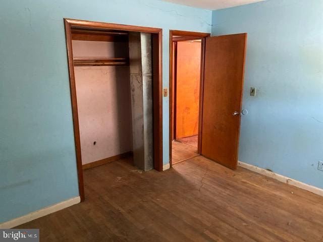 unfurnished bedroom with hardwood / wood-style floors and a closet