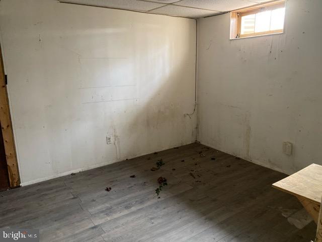 unfurnished room featuring a drop ceiling and hardwood / wood-style flooring