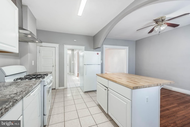 kitchen featuring wooden counters, white cabinets, a center island, ceiling fan, and white appliances