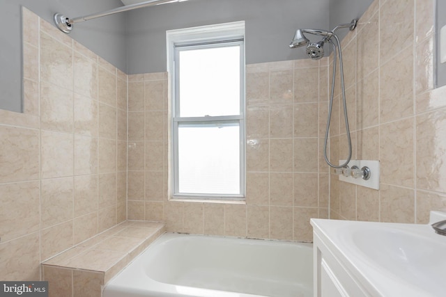 bathroom featuring a bath, plenty of natural light, and sink