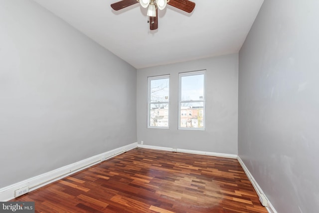 empty room with ceiling fan and dark hardwood / wood-style flooring