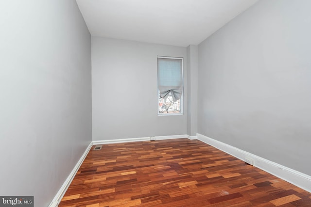 unfurnished room with dark wood-type flooring