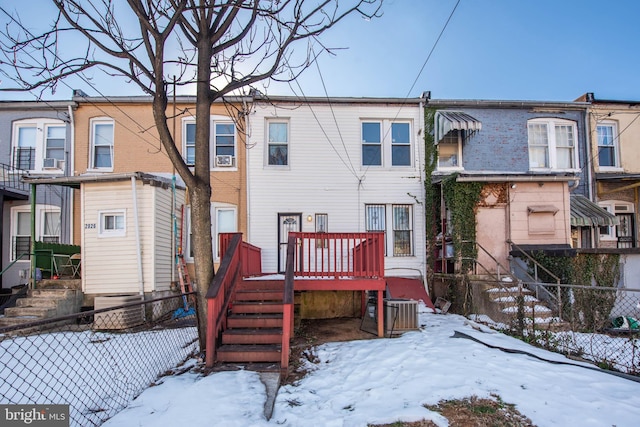 snow covered property featuring central AC unit and a deck