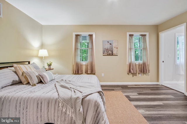 bedroom with multiple windows and hardwood / wood-style floors