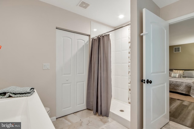 bathroom featuring toilet and curtained shower