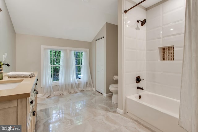 full bathroom featuring tiled shower / bath combo, vanity, lofted ceiling, and toilet