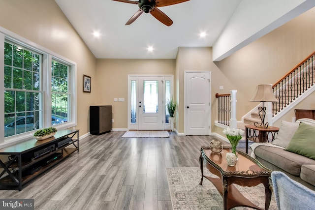 living room with vaulted ceiling, ceiling fan, and light wood-type flooring