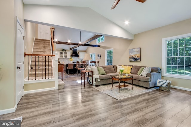 living room featuring lofted ceiling, light hardwood / wood-style flooring, and ceiling fan