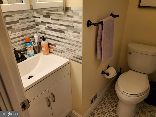 bathroom featuring tasteful backsplash, vanity, and toilet