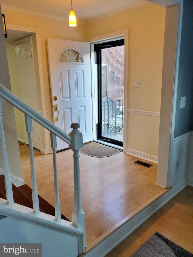 entrance foyer featuring hardwood / wood-style flooring and ornamental molding