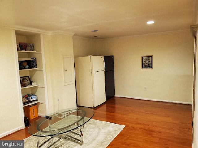 interior space with hardwood / wood-style flooring, crown molding, and white fridge