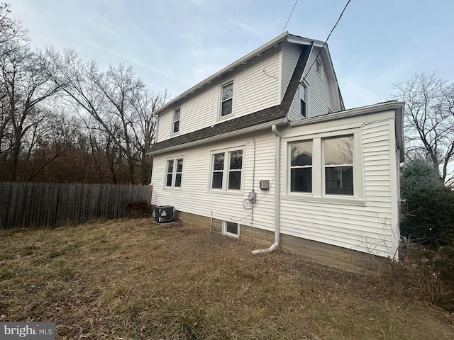 rear view of property featuring a yard and central AC