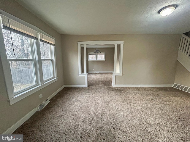 carpeted spare room featuring a textured ceiling