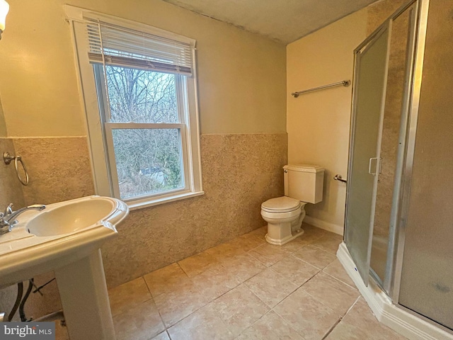 bathroom with toilet, an enclosed shower, and tile patterned flooring