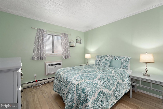 bedroom featuring a wall mounted air conditioner, light hardwood / wood-style flooring, a textured ceiling, baseboard heating, and ornamental molding