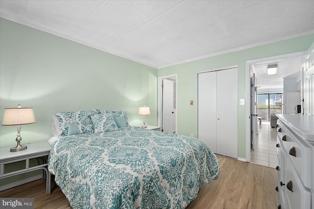 bedroom with ornamental molding, a textured ceiling, light hardwood / wood-style floors, and a closet