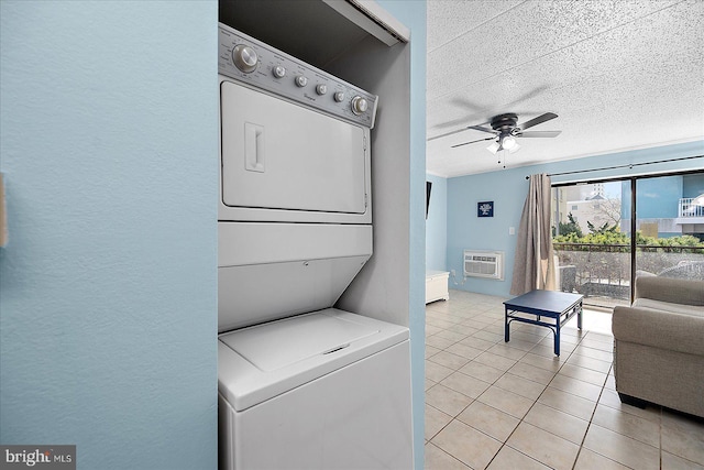 clothes washing area featuring stacked washer and dryer, a textured ceiling, light tile patterned floors, a wall unit AC, and ceiling fan