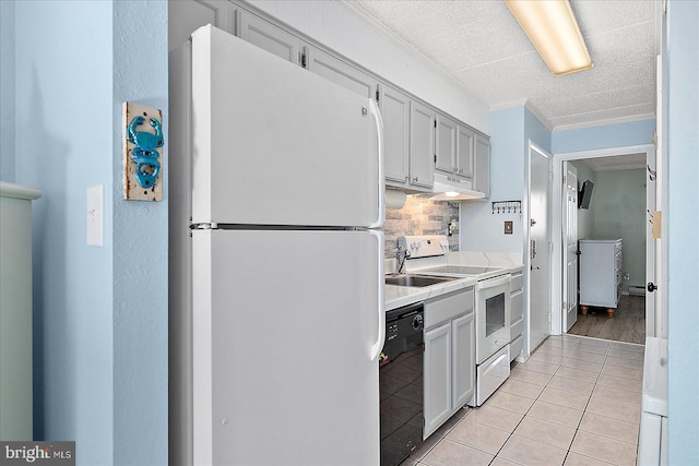 kitchen with tasteful backsplash, white cabinetry, light tile patterned floors, crown molding, and white appliances