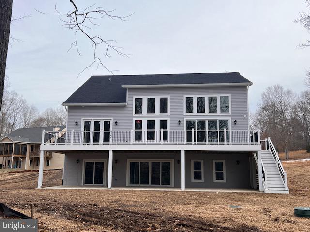 back of property with stairs, a deck, and a patio area