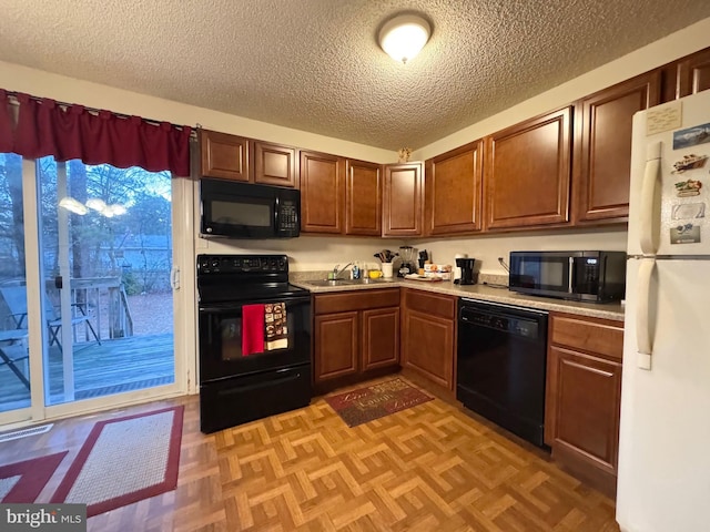 kitchen featuring sink, a textured ceiling, black appliances, and light parquet flooring