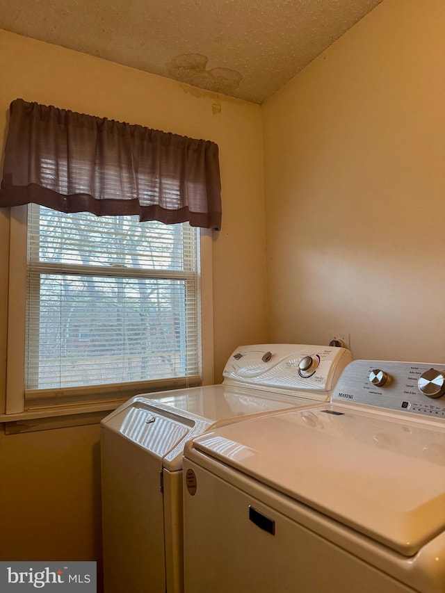 laundry area featuring a textured ceiling and washer and clothes dryer