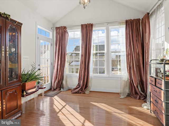 doorway with lofted ceiling and light hardwood / wood-style flooring