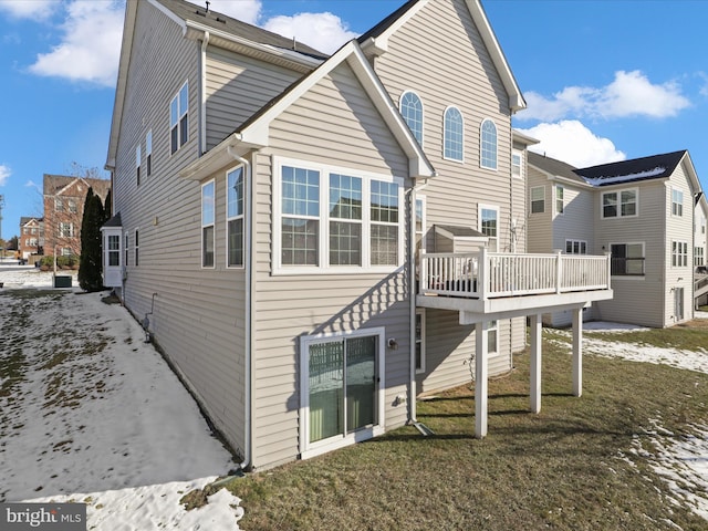 rear view of property with a deck and a lawn