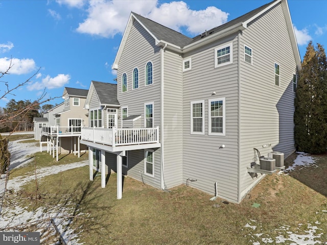 back of property with central AC unit, a yard, and a deck