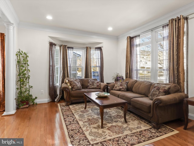 living room with a healthy amount of sunlight, decorative columns, and light hardwood / wood-style flooring