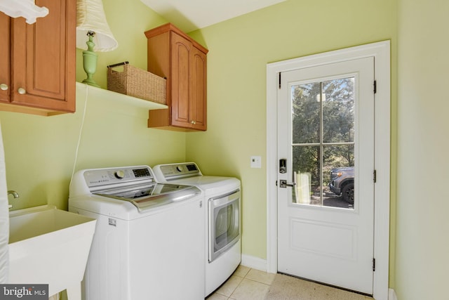 laundry room with sink, light tile patterned floors, cabinets, and washer and dryer