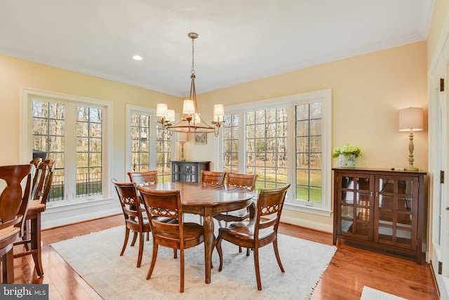 dining space with ornamental molding, light hardwood / wood-style flooring, and a wealth of natural light