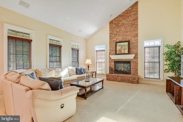 carpeted living room with a stone fireplace and high vaulted ceiling