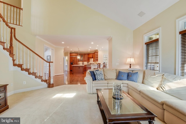 carpeted living room featuring high vaulted ceiling