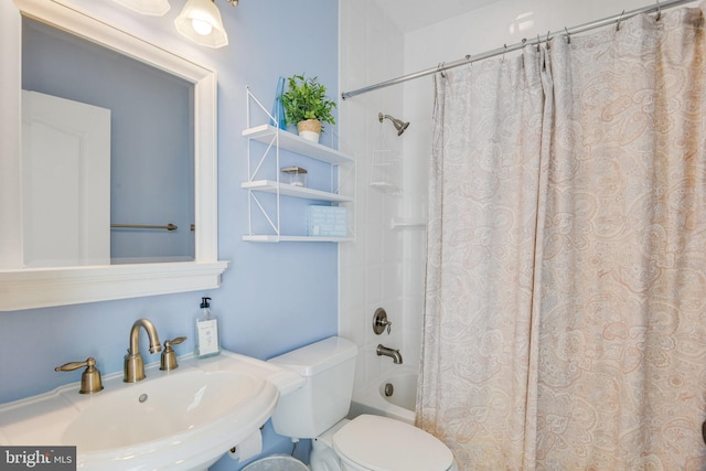 full bathroom with shower / tub combo with curtain, sink, and toilet