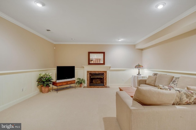 carpeted living room with crown molding and a high end fireplace