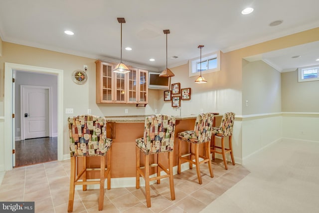 bar with pendant lighting, light tile patterned floors, light stone counters, a wealth of natural light, and ornamental molding