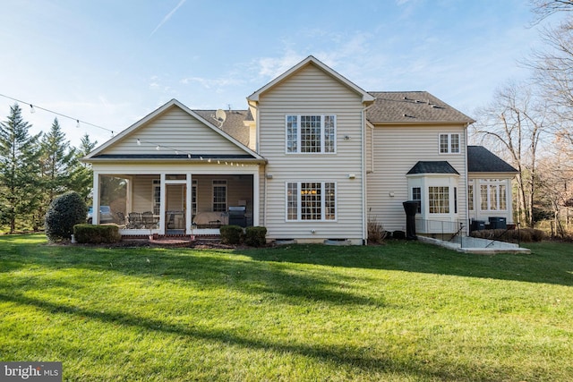 back of house with a sunroom and a lawn