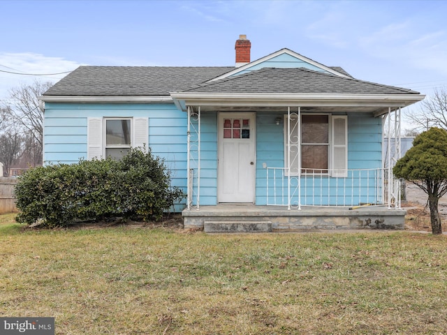 bungalow-style home featuring covered porch and a front lawn