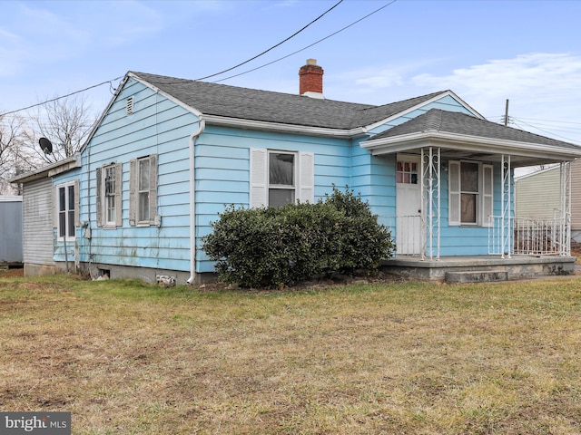 bungalow-style house featuring covered porch and a front yard