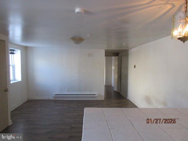 spare room featuring a baseboard radiator and hardwood / wood-style floors